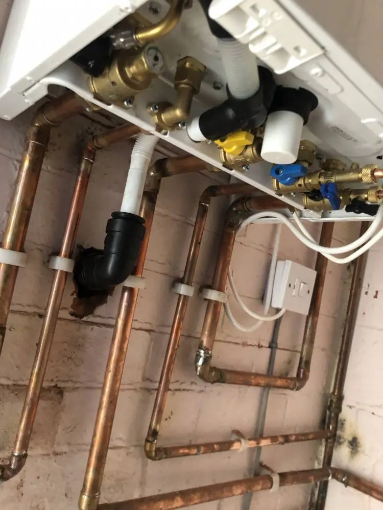 Copper pipework and brass valves under a newly fitted boiler