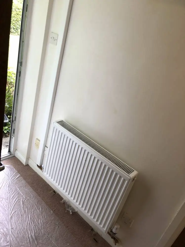 A new white radiator fitted beside a door out to the garden